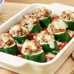 Gefüllte Zucchini mit Hackfleisch und geschmolzenem Käse in einer Auflaufform, bereit zum Servieren.