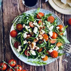 Frischer Rucola Salat mit Kirschtomaten und Feta, garniert mit Croutons. Ein leichter Genuss!