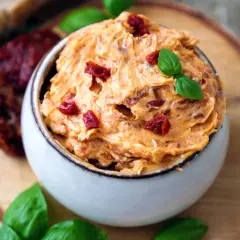Cremige Tomatenbutter, garniert mit Basilikum und getrockneten Tomatenstücken. Ein köstliches Rezept für Tomatenbutter, perfekt zum Dippen oder Bestreichen.