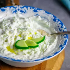 Cremiger Tzatziki-Dip mit Gurkenstücken und Olivenöl, perfekt für dein nächstes Tzatziki Rezept.