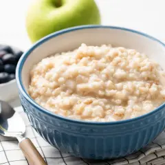 Herzhaftes Porridge-Rezept mit Blaubeeren und Apfel. Ein Löffel wartet auf den Genuss.