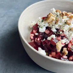Schüssel mit roter Bete, Feta und Walnüssen. Ein köstlicher roter Bete Feta Salat, garniert mit Kräutern.