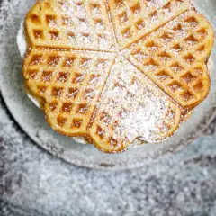 Herzförmige Waffeln, bestäubt mit Puderzucker, ein köstliches Rezept für süße Momente.