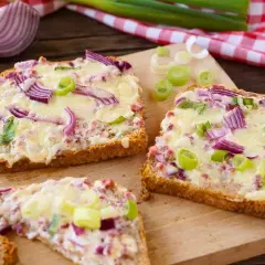 Drei Scheiben Brot mit geschmolzenem Käse, roten Zwiebeln und Frühlingszwiebeln. Ein schnelles Abendessen, warm und lecker.