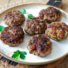 Sechs goldbraune Buletten, frisch gebraten, liegen auf einem Teller. Ein einfaches, aber köstliches Buletten Rezept.