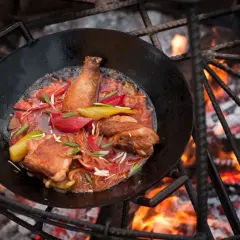Hähnchen mit Gemüse in einer Pfanne über offenem Feuer. Tolle Camping Essen Ideen für ein herzhaftes Mahl.