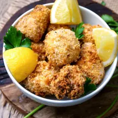 Knusprige Blumenkohl-Bites aus dem Airfryer, garniert mit Zitrone und Petersilie.