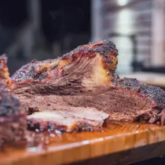 Saftiges Beef Brisket, welches Fleisch für BBQ-Liebhaber. Rauchig, zart und perfekt geschnitten auf einem Holzbrett.