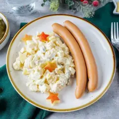 Kartoffelsalat mit Würstchen und Sternen – ein Klassiker der 10 besten Weihnachtsessen. Dazu Cornichons und Senf.