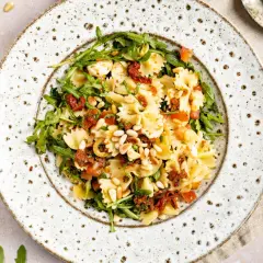 Mediterraner Salat mit Farfalle, getrockneten Tomaten, Rucola und Pinienkernen. Ein leichter Genuss!