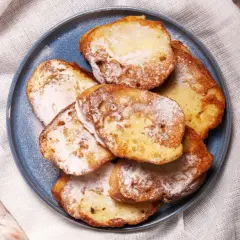 Ein Teller mit goldbraunem French Toast, bestäubt mit Puderzucker. Ein süßer Genuss für jeden Morgen.
