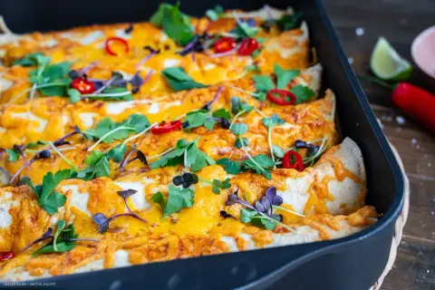 Herzhafte Enchiladas mit geschmolzenem Käse, garniert mit frischen Kräutern und Chilis. Ein köstliches Enchiladas Rezept für jeden Anlass.