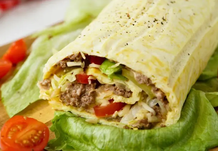 Herzhafte Big Mac Rolle gefüllt mit Hackfleisch, Salat, Tomaten und Käse, serviert auf knackigem Salatblatt.