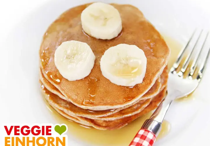 Leckere, fluffige bananen pancakes ohne ei, garniert mit Bananenscheiben und Sirup. Ein Genuss für jeden Morgen!