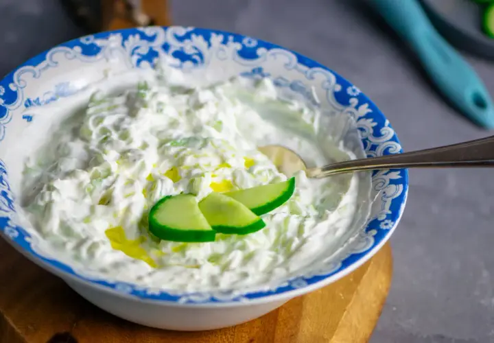 Cremiger Tzatziki-Dip mit Gurkenstücken und Olivenöl, perfekt für dein nächstes Tzatziki Rezept.