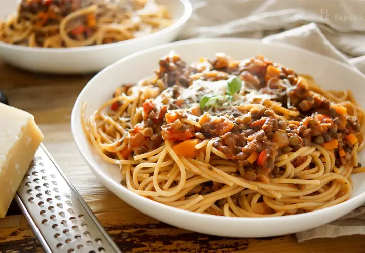 Herzhafte vegetarische Bolognese mit Linsen und Spaghetti, garniert mit Parmesan und Basilikum.
