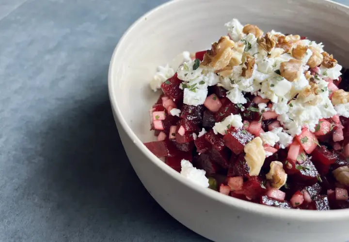 Schüssel mit roter Bete, Feta und Walnüssen. Ein köstlicher roter Bete Feta Salat, garniert mit Kräutern.