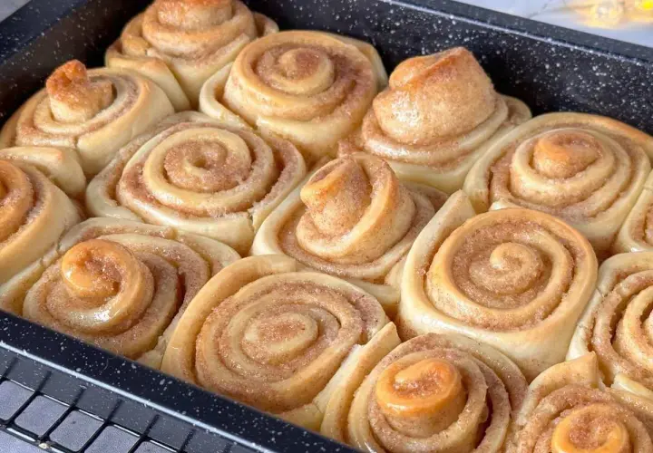 Frisch gebackene Zimtschnecken im Blech, bereit für das Zimtschnecken Rezept. Goldbraun und duftend.