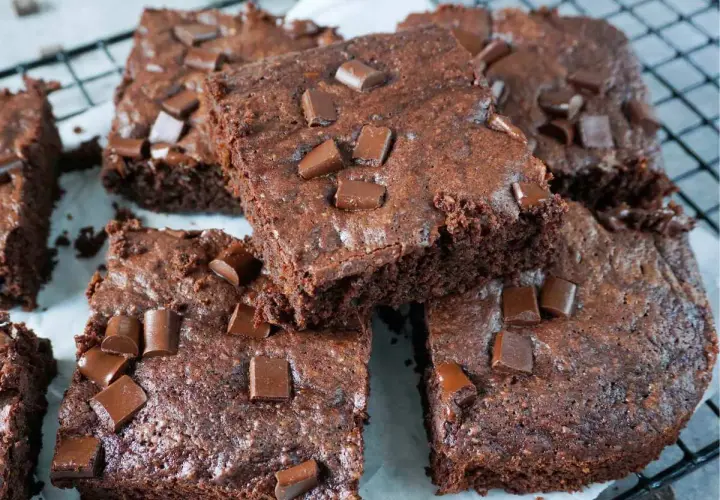Saftige Zucchini Brownies mit Schokostückchen, auf einem Gitterrost arrangiert.