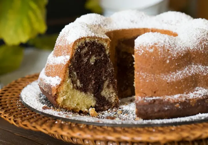 Ein köstlicher Marmorkuchen, frisch gebacken nach einem einfachen Rezept, bestäubt mit Puderzucker.