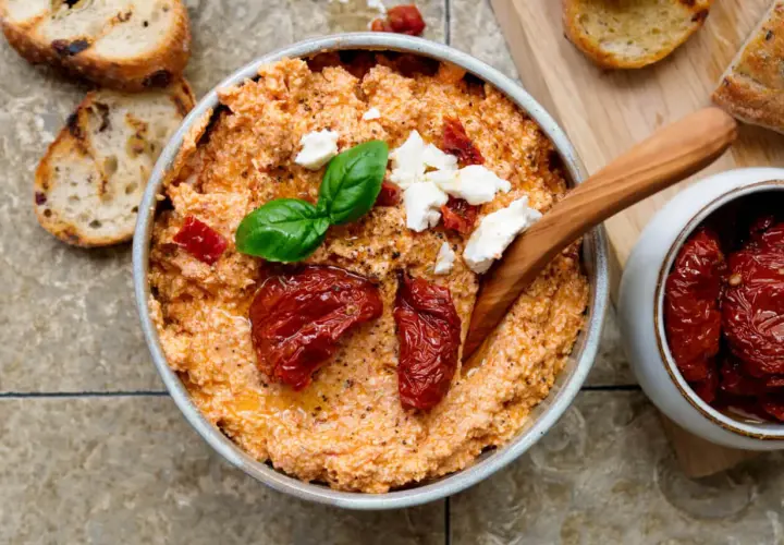 Cremiger Feta-Dip mit getrockneten Tomaten, Basilikum und Brot.