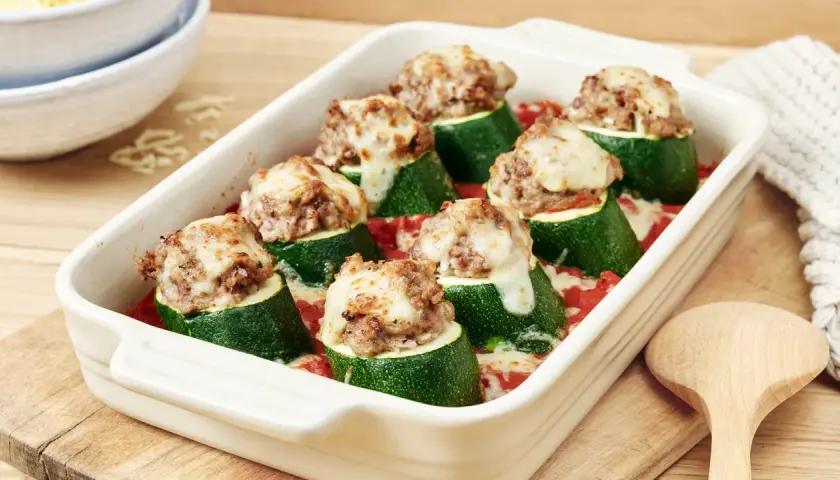 Gefüllte Zucchini mit Hackfleisch und geschmolzenem Käse in einer Auflaufform, bereit zum Servieren.