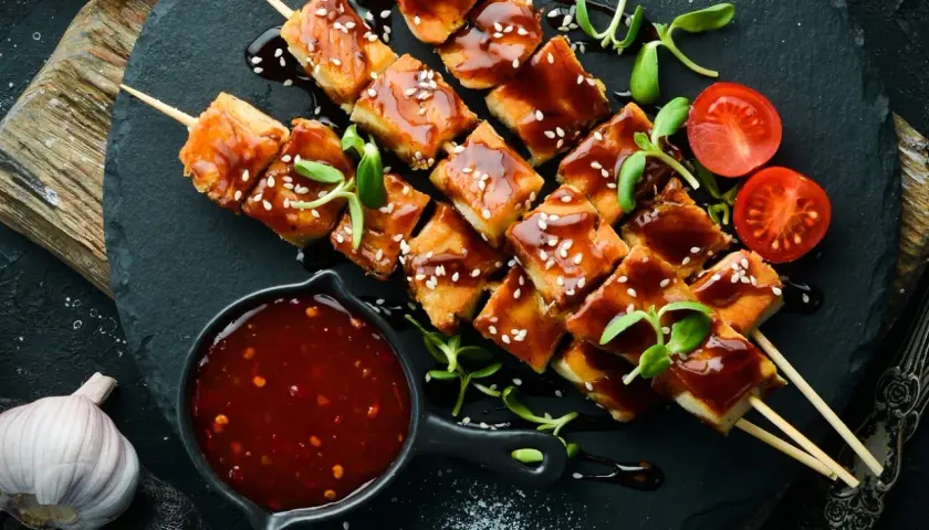 Hähnchenspieße mit glänzender Teriyaki-Sauce, Sesam und Kirschtomaten. Ein einfaches Teriyaki Sauce Rezept zum Nachmachen.