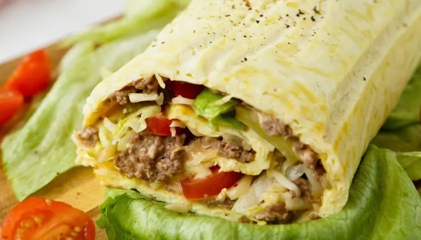 Herzhafte Big Mac Rolle gefüllt mit Hackfleisch, Salat, Tomaten und Käse, serviert auf knackigem Salatblatt.