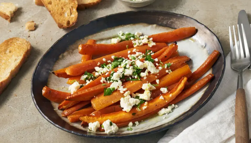 Geröstete Karotten mit Feta und Petersilie, ein köstliches Gericht, das perfekt zu den vielen Karotten Rezepten passt. Dazu geröstetes Brot.