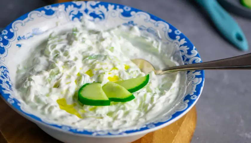 Cremiger Tzatziki-Dip mit Gurkenstücken und Olivenöl, perfekt für dein nächstes Tzatziki Rezept.