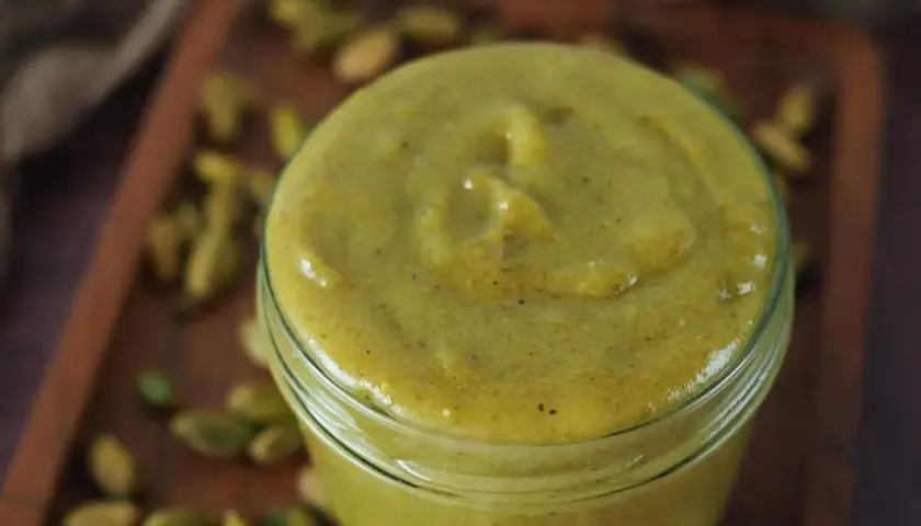 Selbstgemachte Pistaziencreme in einem Glas, umgeben von ganzen Pistazien. Perfekt zum Backen und Genießen.