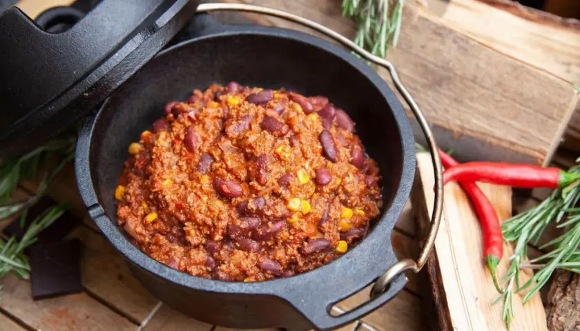 Herzhaftes Chili con Carne, dampfend im Dutch Oven, mit roten Bohnen und Mais. Perfekt für kalte Tage!