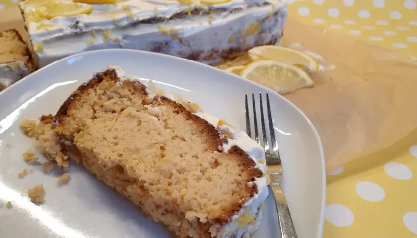 Ein Stück saftiger low carb Kuchen mit Zitronencreme und frischen Zitronenscheiben. Perfekt für Genießer!