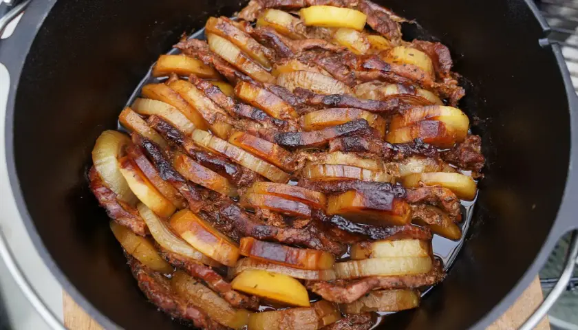 Schichtfleisch im Dutch Oven: saftige Fleischscheiben und Kartoffeln, goldbraun geschmort. Ein Festmahl!
