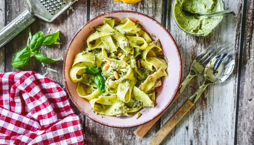 Bandnudeln mit cremigem Avocado Pesto, garniert mit Pinienkernen und Basilikum. Ein köstliches Gericht, das Lust auf mehr macht.