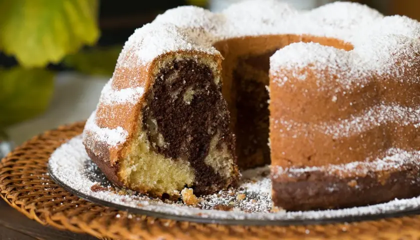 Ein köstlicher Marmorkuchen, frisch gebacken nach einem einfachen Rezept, bestäubt mit Puderzucker.