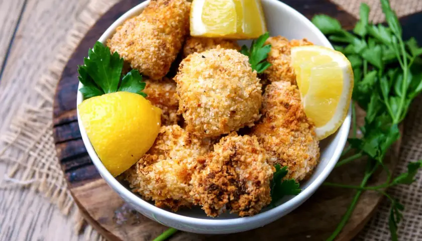 Knusprige Blumenkohl-Bites aus dem Airfryer, garniert mit Zitrone und Petersilie.