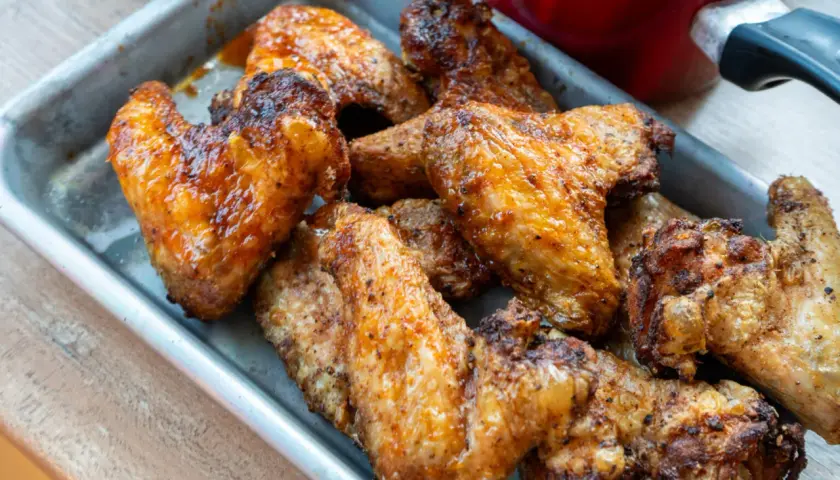 Saftige, goldbraune Buffalo Wings in einer Metallschale, bereit zum Genießen.