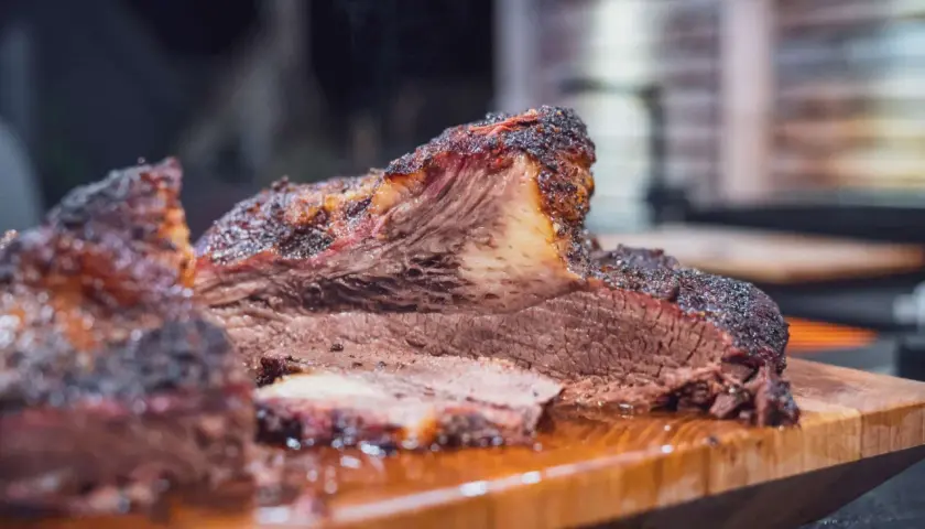 Saftiges Beef Brisket, welches Fleisch für BBQ-Liebhaber. Rauchig, zart und perfekt geschnitten auf einem Holzbrett.