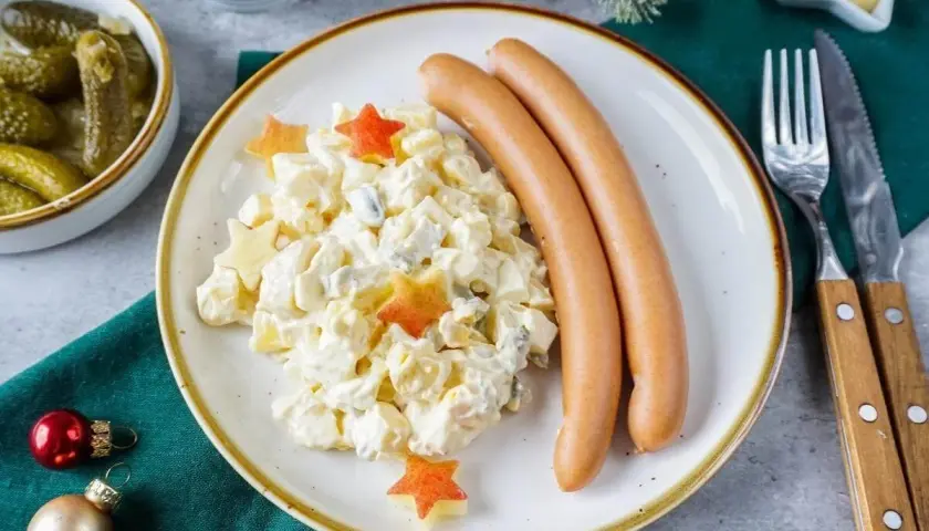 Kartoffelsalat mit Würstchen und Sternen – ein Klassiker der 10 besten Weihnachtsessen. Dazu Cornichons und Senf.
