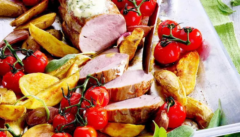 Saftiges Schweinefilet mit Kräuterbutter, dazu Rosmarinkartoffeln und Kirschtomaten. Ein köstliches Schweinefilet Rezept für Genießer.