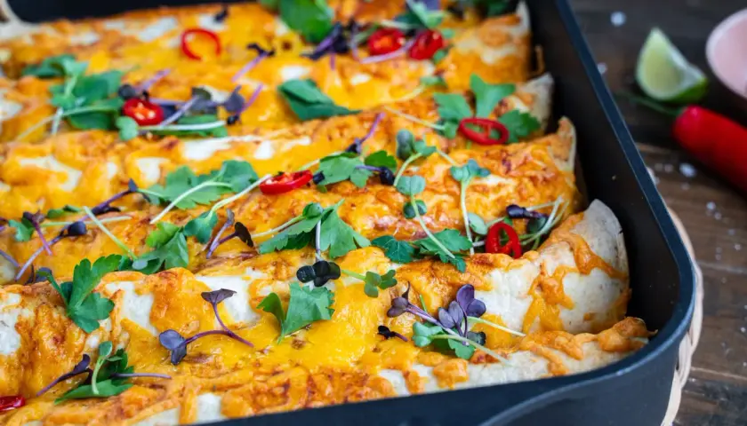Herzhafte Enchiladas mit geschmolzenem Käse, garniert mit frischen Kräutern und Chilis. Ein köstliches Enchiladas Rezept für jeden Anlass.
