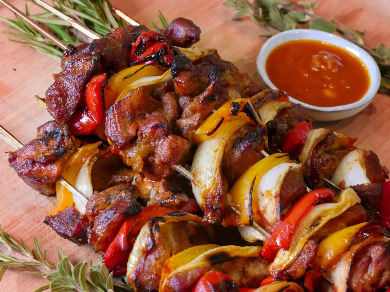 Saftige Spieße mit Fleisch, Paprika und Zwiebeln, perfekt für ein Schaschlik Rezept. Dazu eine würzige Sauce.