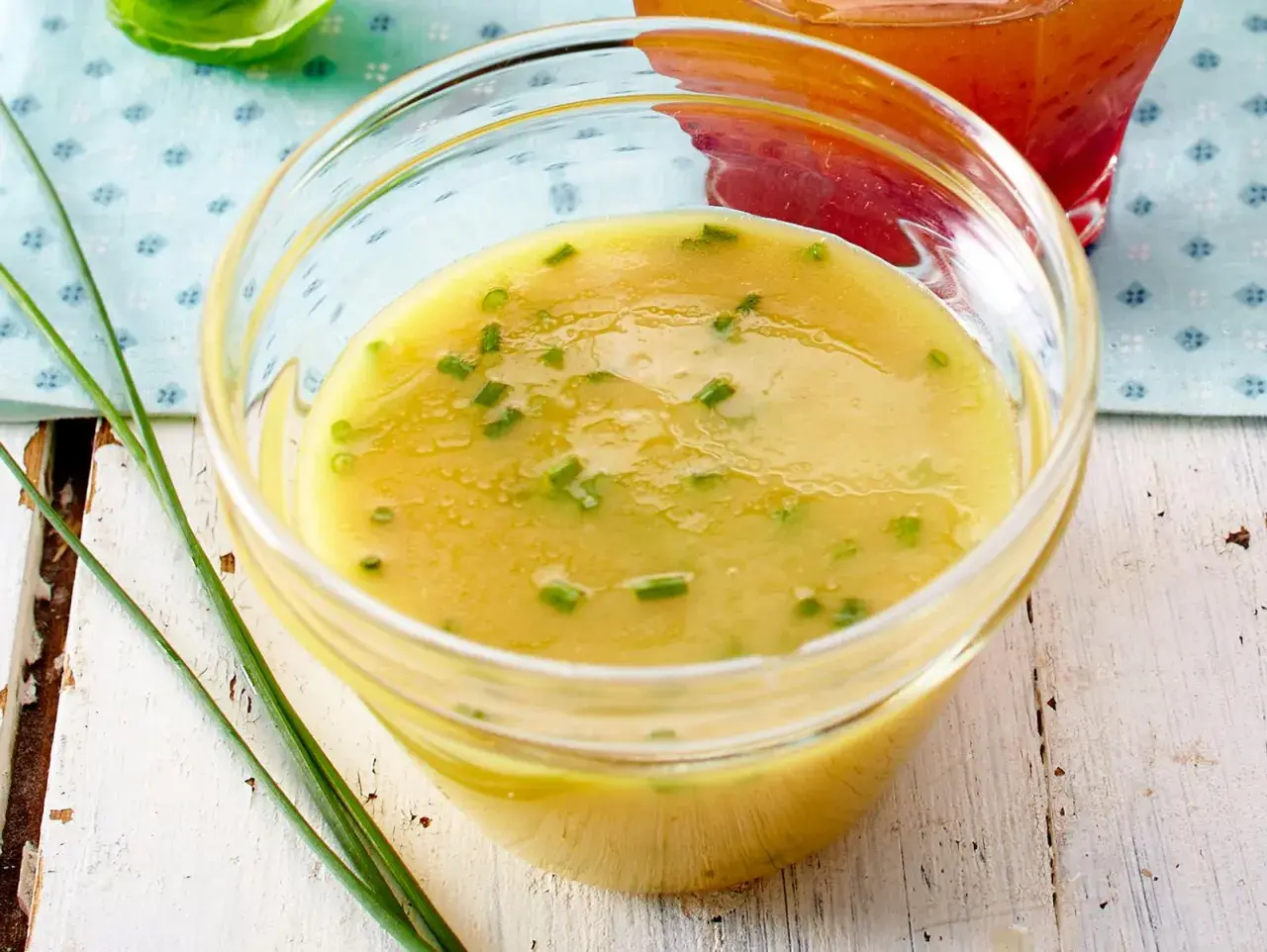Ein Glas mit cremigem honig senf dressing, garniert mit Schnittlauch. Perfekt für einen frischen Salat.