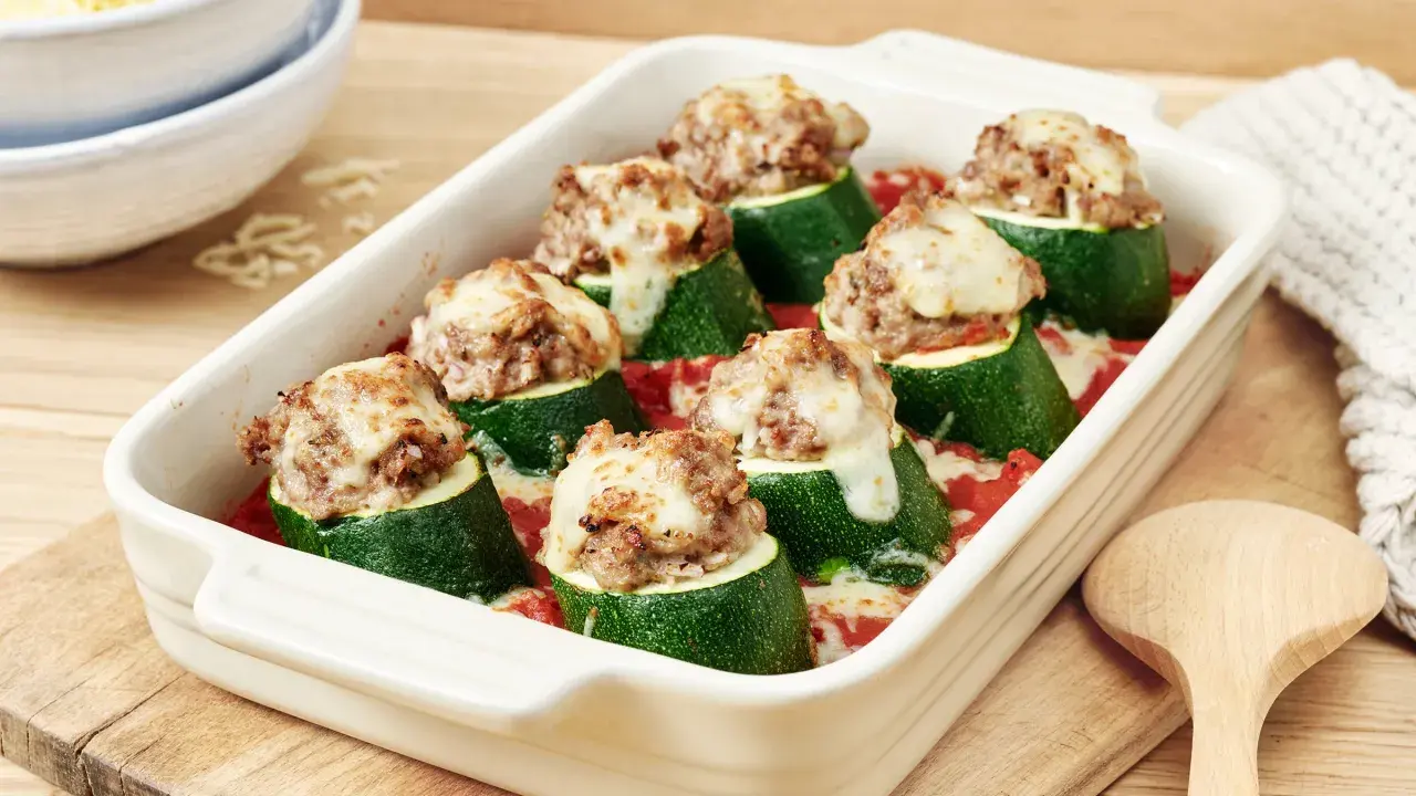 Gefüllte Zucchini mit Hackfleisch und geschmolzenem Käse in einer Auflaufform, bereit zum Servieren.