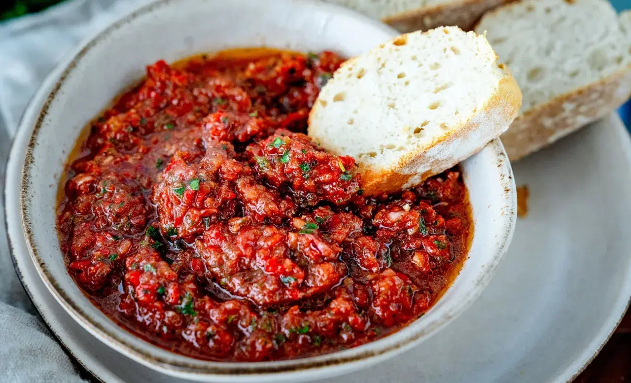Würziges Acili Ezme, ein scharfer Paprika-Dip, wird mit frischem Brot serviert.