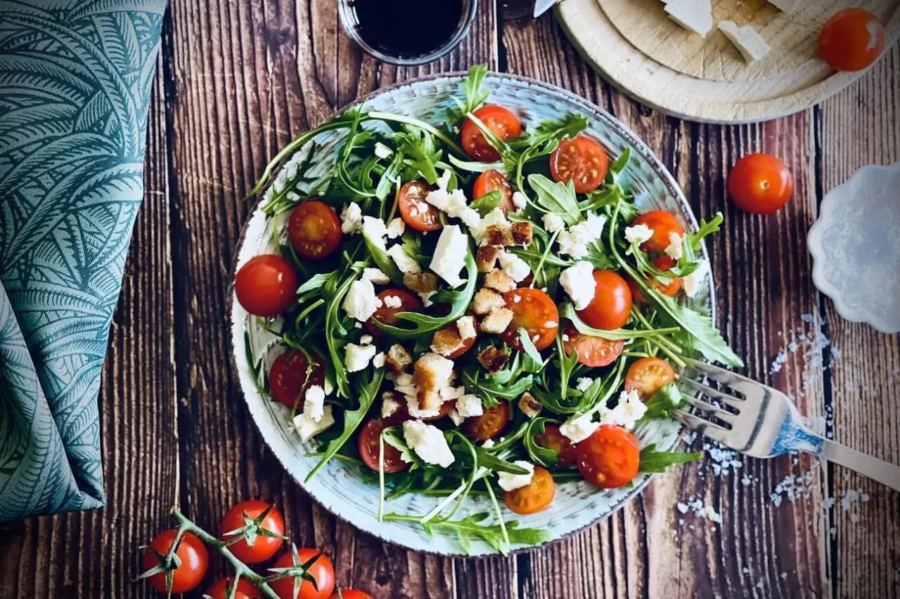 Frischer Rucola Salat mit Kirschtomaten und Feta, garniert mit Croutons. Ein leichter Genuss!