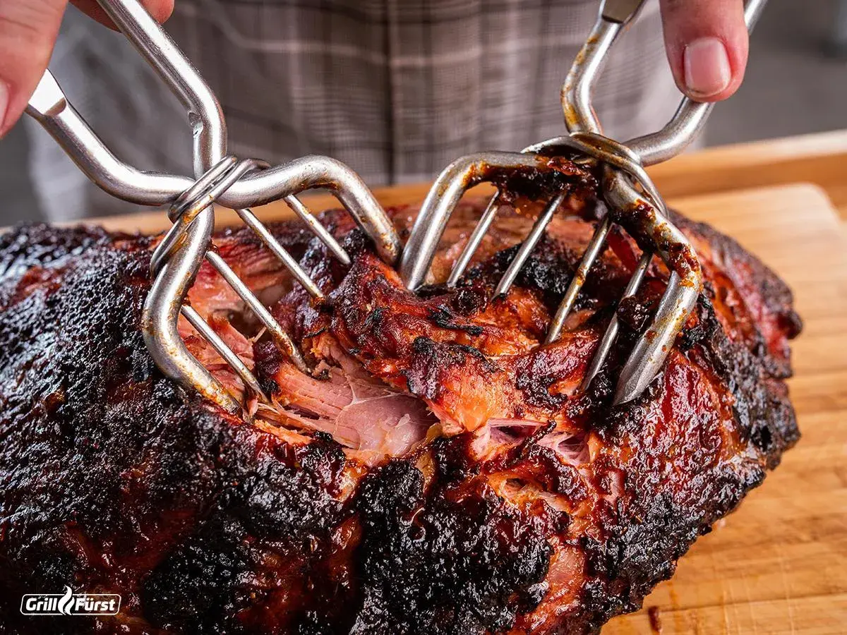 Pulled Pork aus dem Smoker wird mit Fleischgabeln zerteilt. Ein perfektes pulled pork rezept smoker Ergebnis!