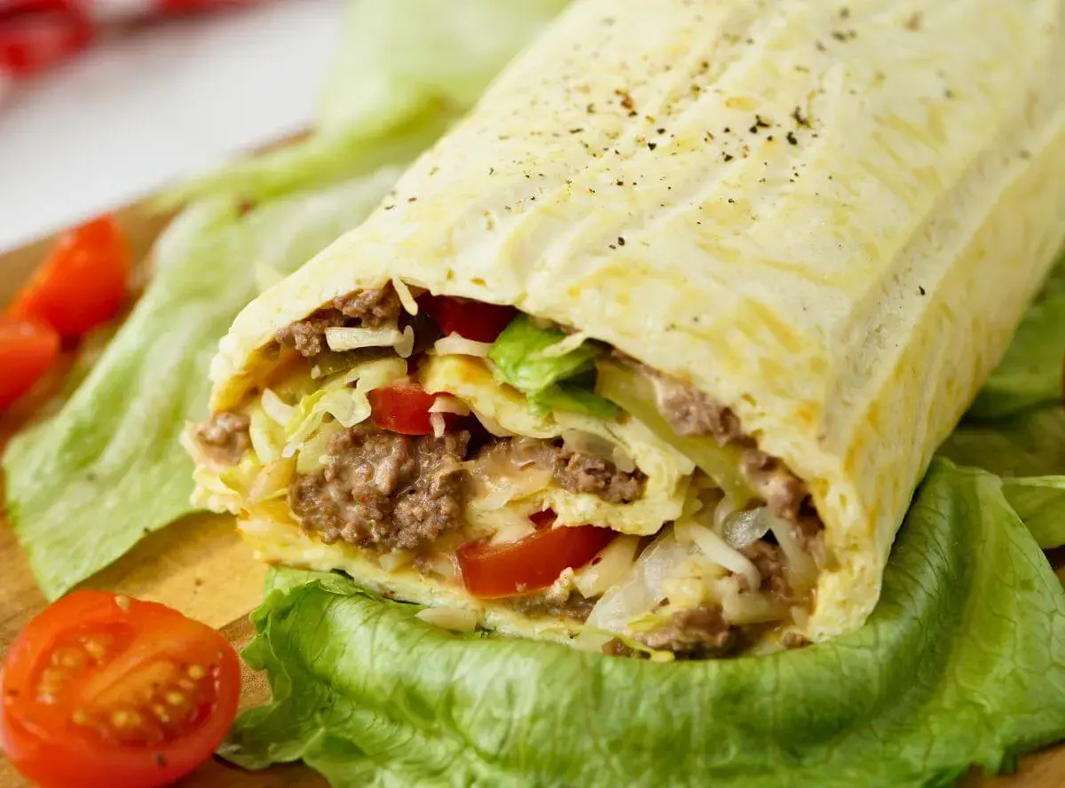 Herzhafte Big Mac Rolle gefüllt mit Hackfleisch, Salat, Tomaten und Käse, serviert auf knackigem Salatblatt.