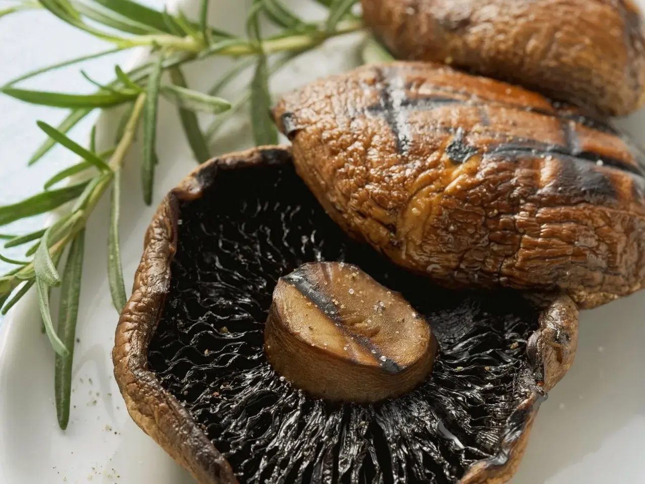 Saftige, gegrillte Champignons mit Rosmarin und grobem Salz. Perfekt für ein sommerliches BBQ.